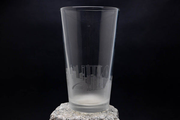 a tall glass sitting on top of a rock