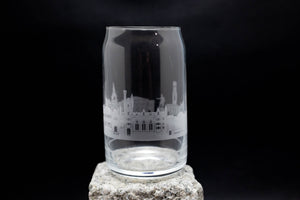 a glass on a rock with a building in the background