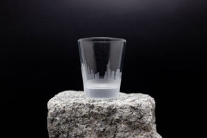 a shot glass sitting on top of a rock