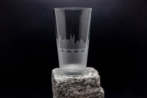 a tall glass sitting on top of a rock