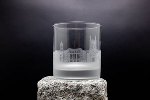 a glass with a building on it sitting on a rock