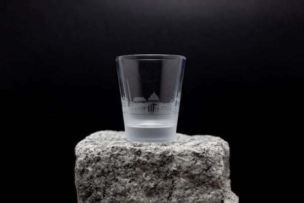 a shot glass sitting on top of a rock