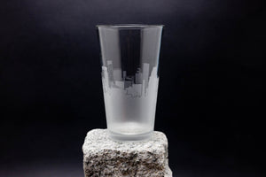 a tall glass sitting on top of a rock