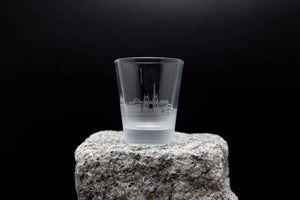 a shot glass sitting on top of a rock