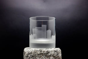 a glass on a rock with a city in it