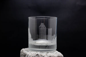 a glass with a building in it on a rock