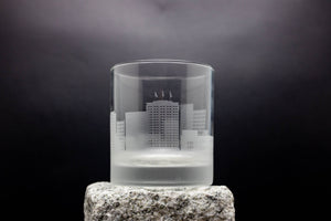 a glass with a building in it on a rock