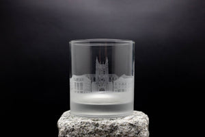 a glass with a castle on it sitting on a rock