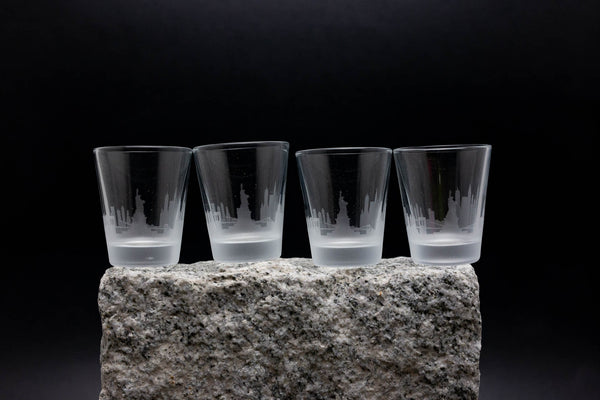 three shot glasses sitting on top of a rock