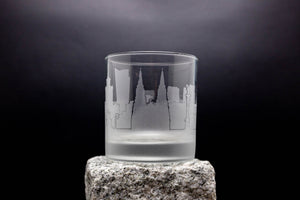 a glass with a castle on it sitting on a rock