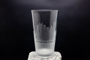 a clear glass with a city skyline etched on it