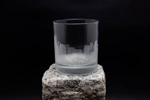 a glass sitting on top of a rock