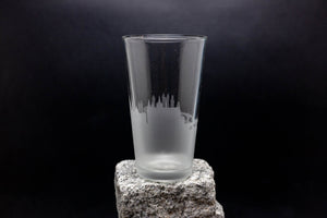 a tall glass sitting on top of a rock