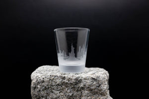 a shot glass sitting on top of a rock