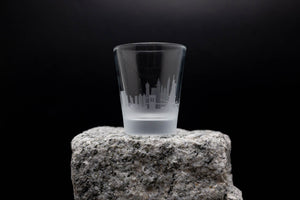 a shot glass sitting on top of a rock