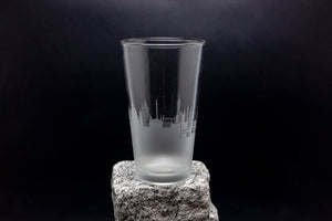 a tall glass sitting on top of a rock