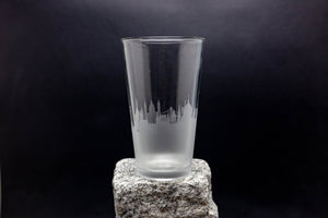 a tall glass sitting on top of a rock