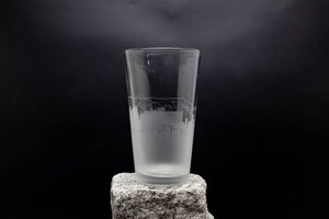 a tall glass sitting on top of a rock