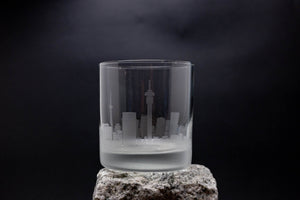 a glass with a city in it sitting on a rock