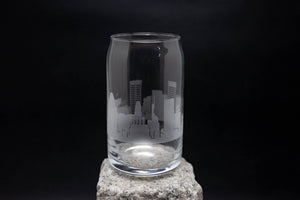 a glass on a rock with a city skyline etched on it