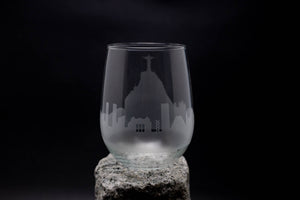 a glass with a church on it sitting on a rock