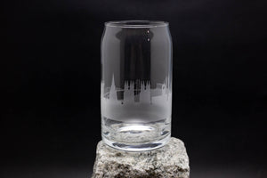 a glass on a rock with a city skyline in the background