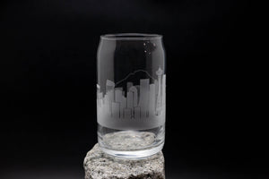 a glass on a rock with a city skyline etched on it
