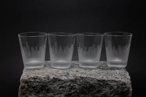 four glasses sitting on top of a rock