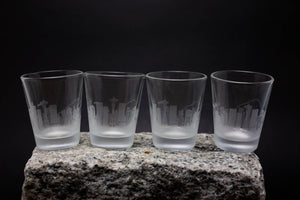 three shot glasses sitting on top of a rock