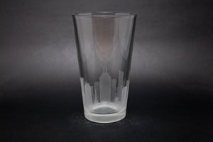 a tall glass with a city skyline etched on it
