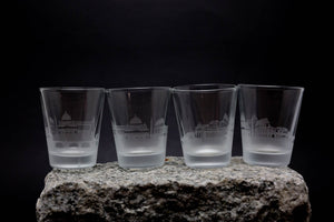four shot glasses sitting on top of a rock