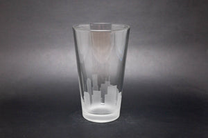 a clear glass with a city skyline etched on it