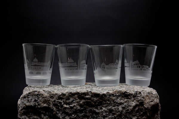 three shot glasses sitting on top of a rock